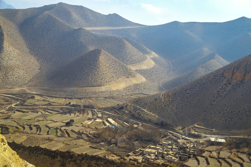 Arid Mustang valley with terraced fields and a village